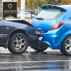 In Clearwater, Florida, a dark blue car rear-ends a blue hatchback on a wet road, with both vehicles showing crash damage