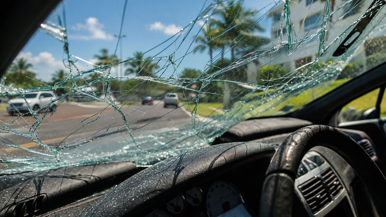 A vehicle involved in a Florida car accident, with shattered windshield glass spreading across the driver’s view